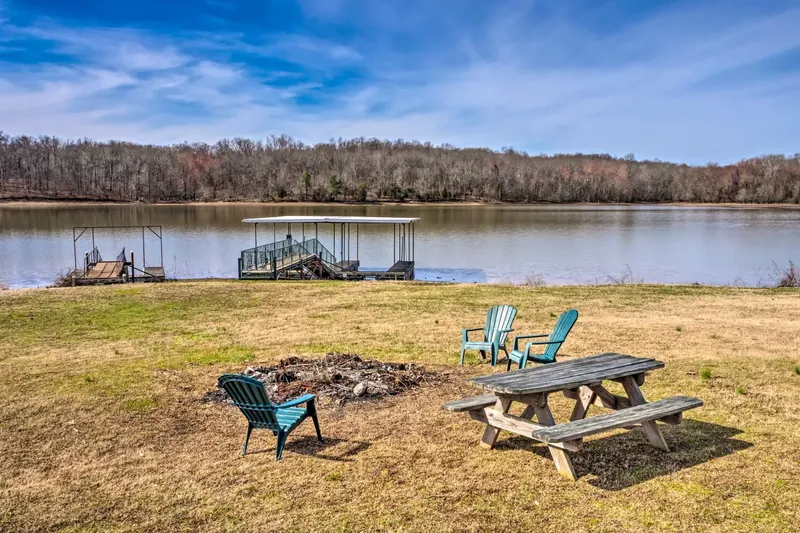 Lawn with fire pit and picnic table facing the dock